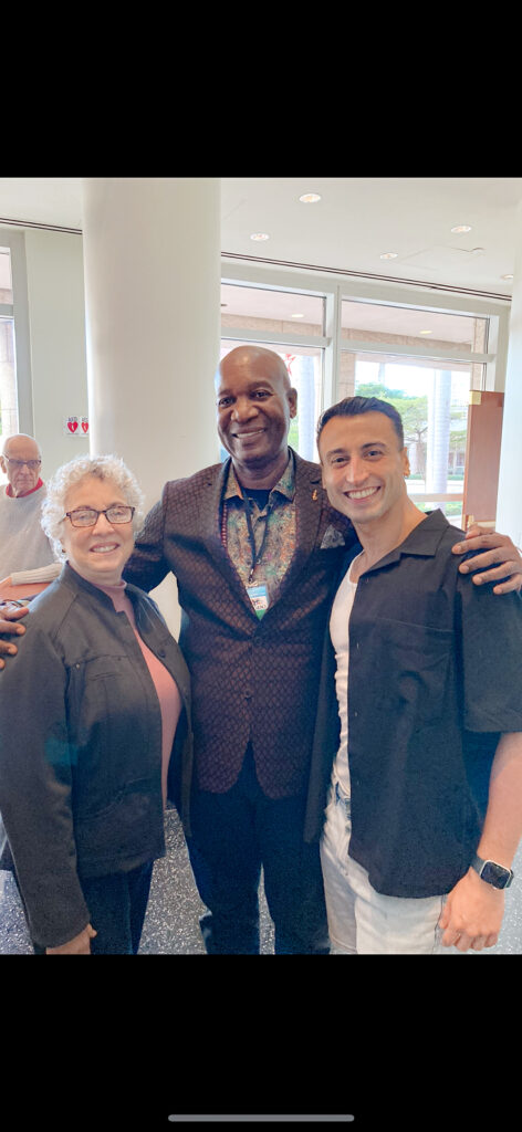 Richard Villaverde poses candidly with an older woman and a tall Black man at an event.