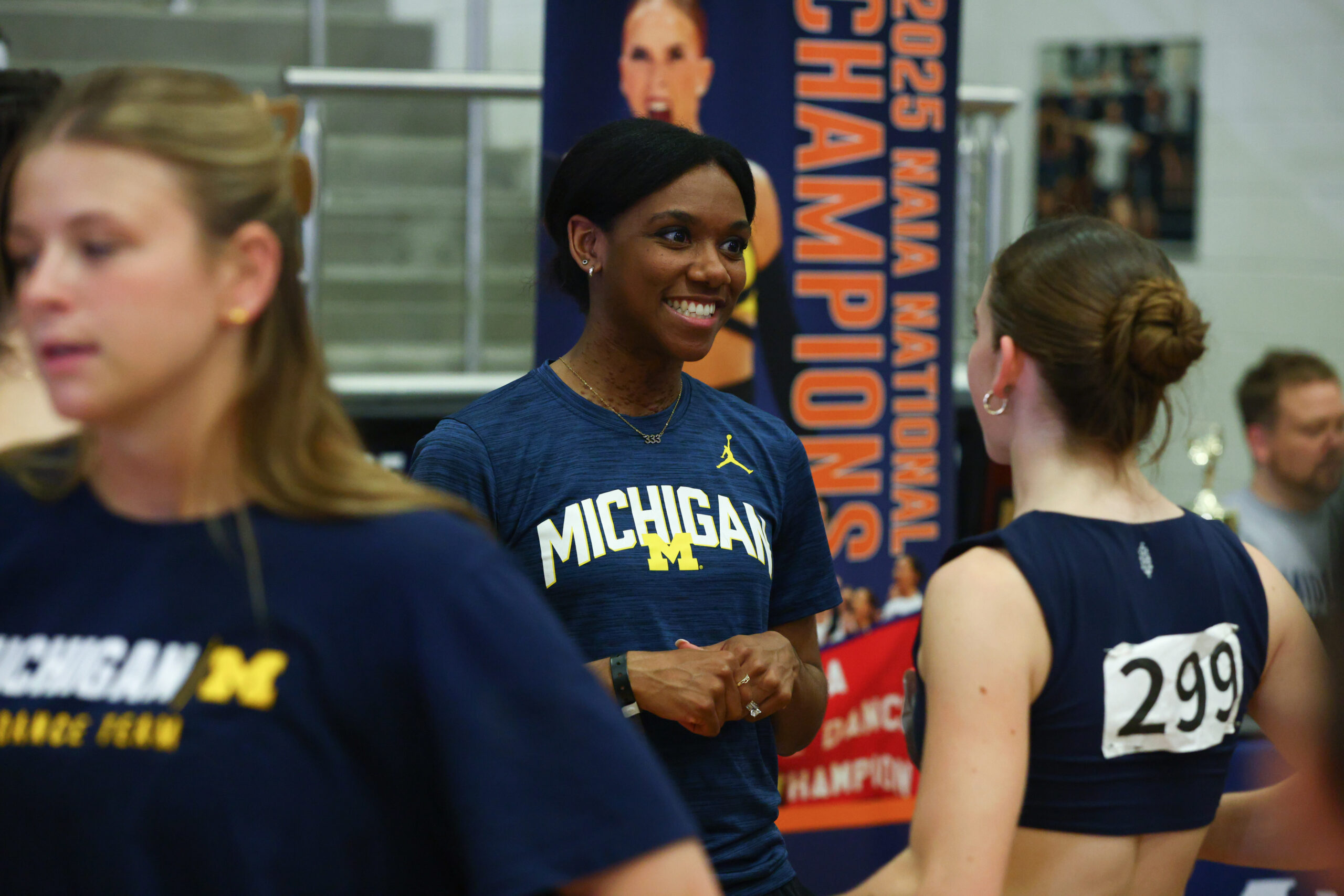 At a recruiting event, a dance team representative from the University of Michigan speaks with an auditioning dancer.